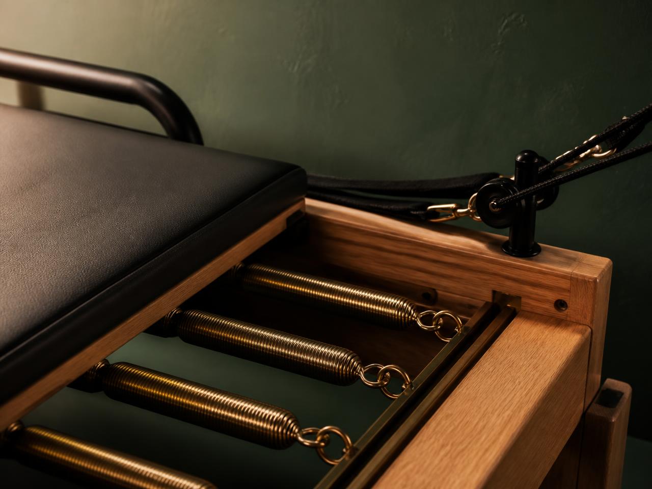 Close view of a reformer carriage with its springs and foot bar